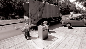 The container lid is raised vertically, which allows the truck crane to access the plastic container.