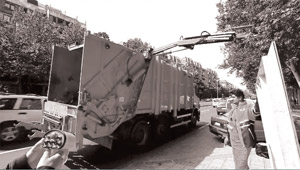 The worker hangs the handle of the plastic container to the crane hook.